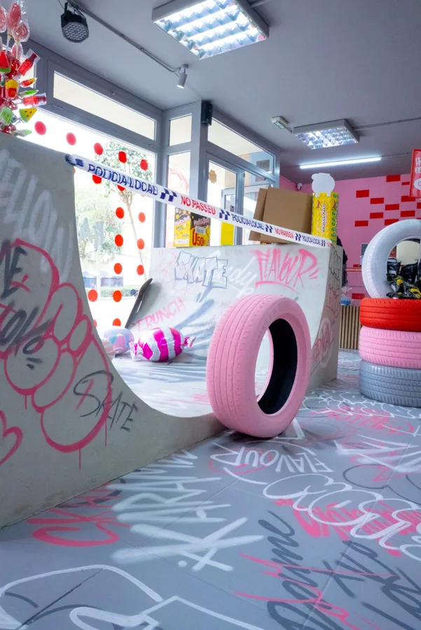 Rampa d'skate amb un pneumàtic rosa sobre el terra grafitejat de la botiga